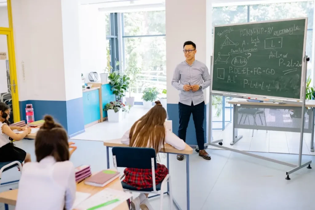 Predavač ispred table pred malom grupom studenata